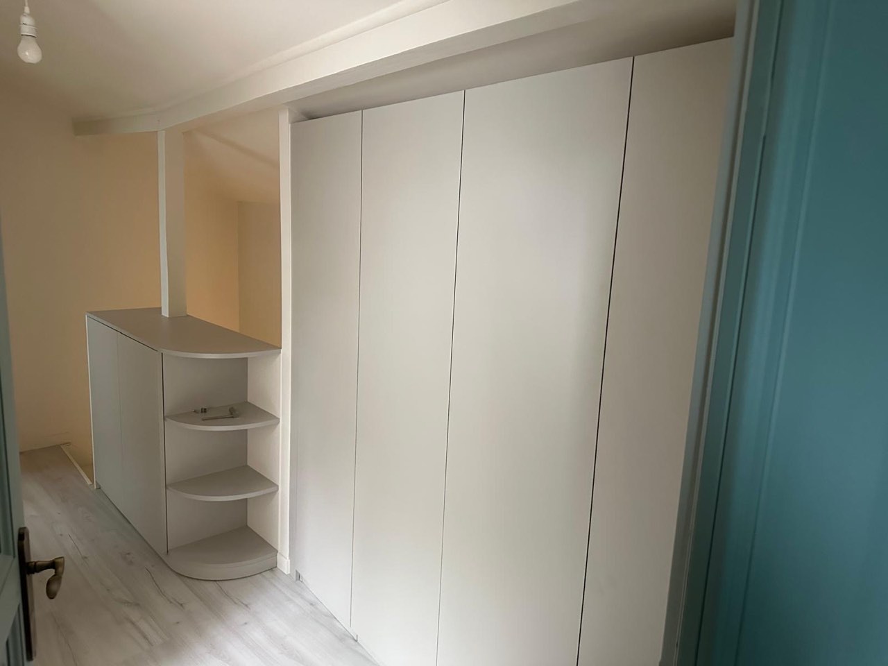 Dressing sur mesure aux façades blanches avec penderie et étagères d'angle, sol stratifié clair — chantier à Cormeilles