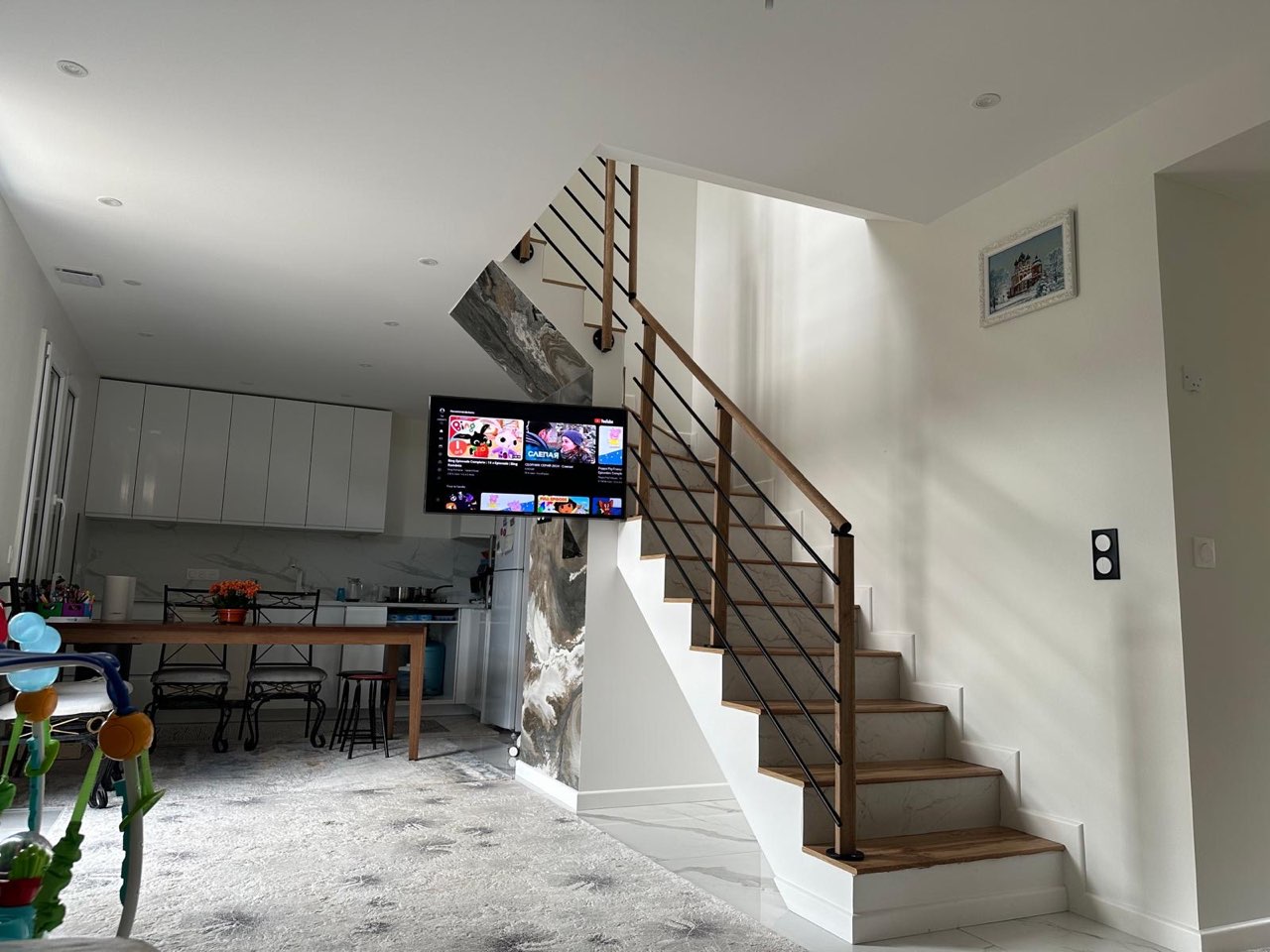 Escalier à marches en bois et rampe en métal noir ouvert sur un séjour et une cuisine contemporains — chantier à Touques