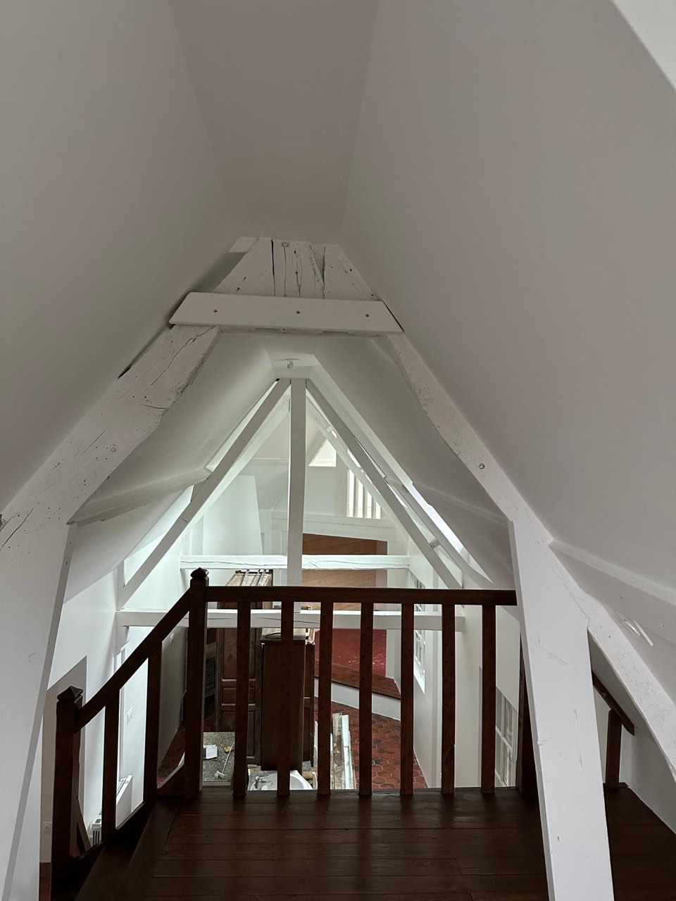 Palier et mezzanine sous charpente normande repeinte en blanc, garde-corps en bois