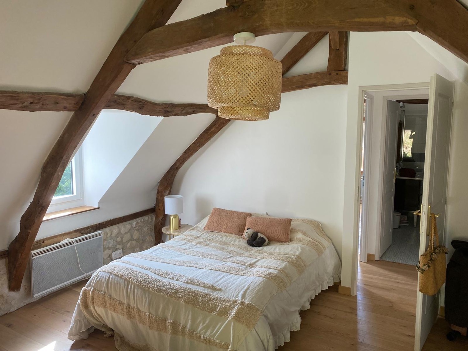 Chambre avec poutres anciennes apparentes et parquet chêne, charpente normande conservée