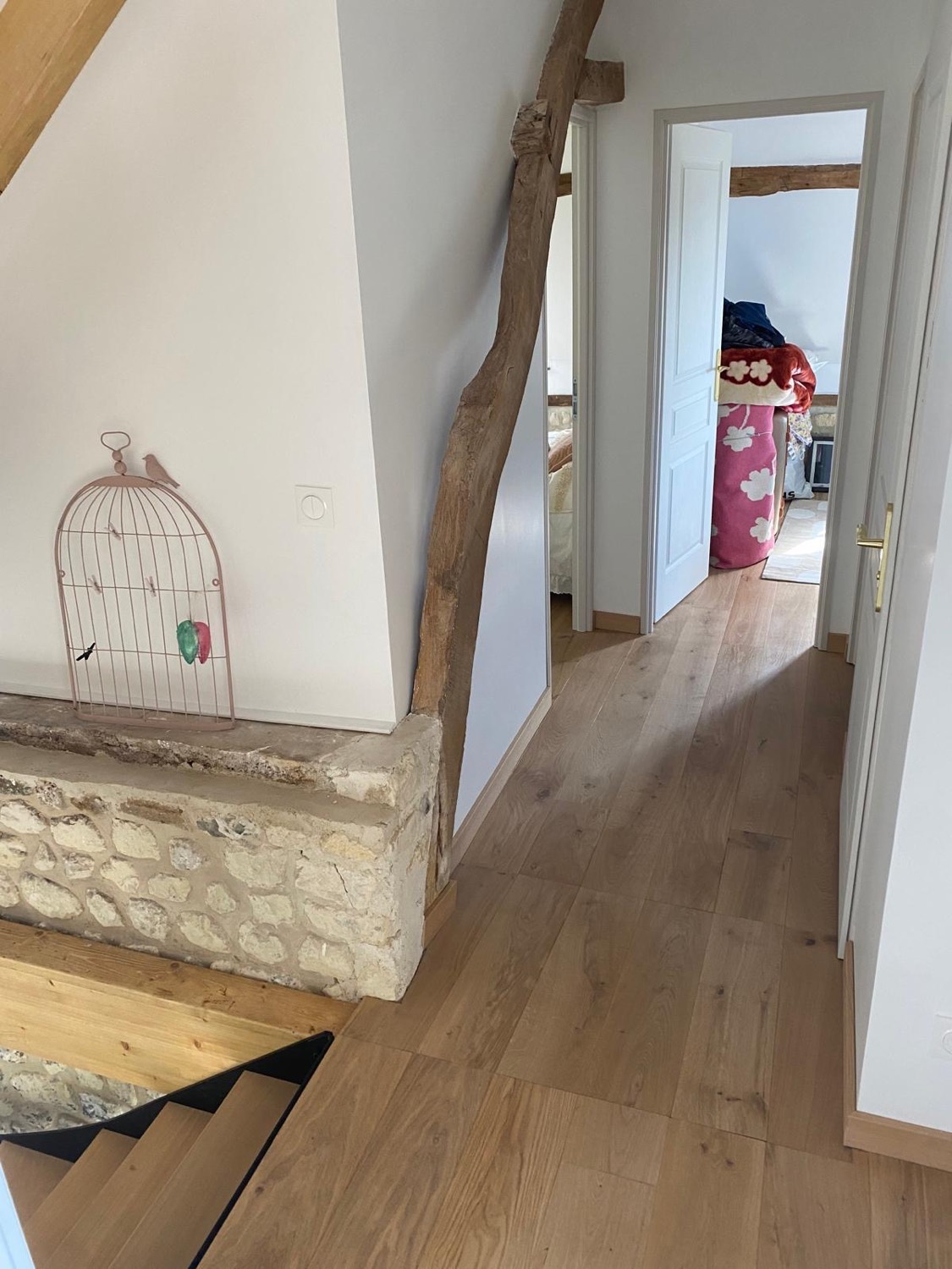 Palier et circulation de l'étage avec muret en pierre conservé, poutre ancienne et parquet chêne