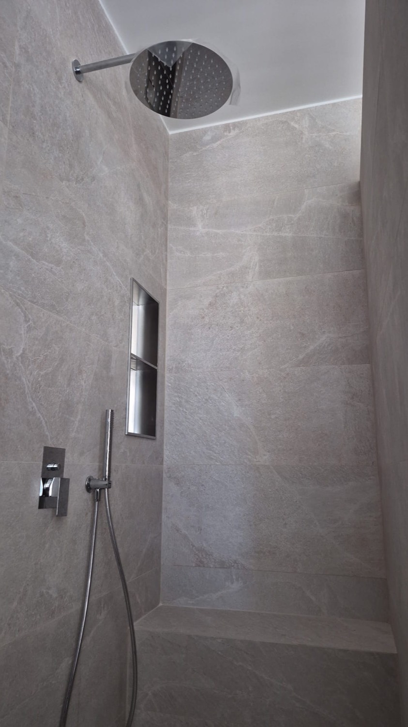 Douche à l'italienne en faïence effet pierre grise avec niche et ciel de pluie