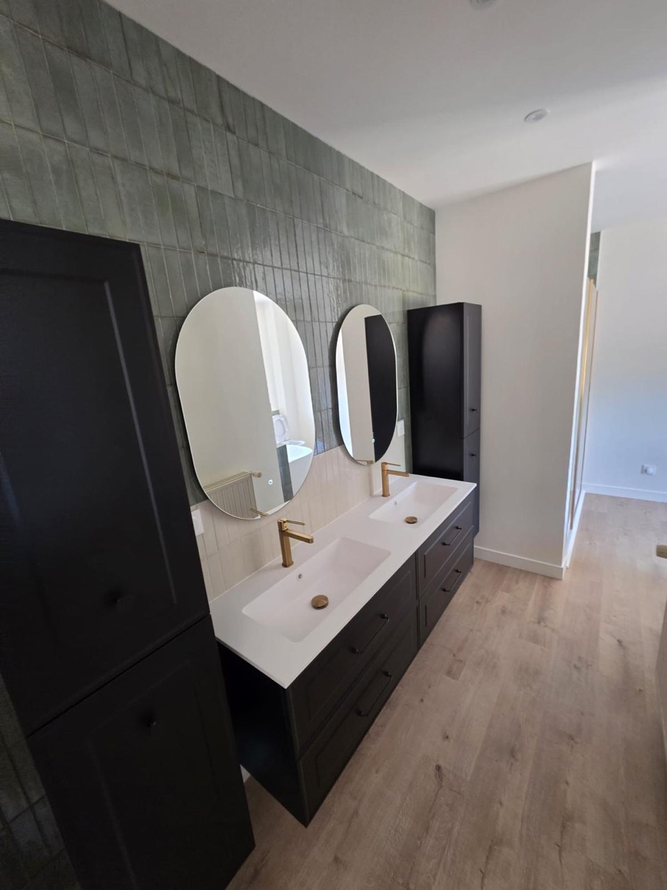 Salle de bain avec double vasque, meubles noirs, robinetterie laiton et faïence verte effet zellige — chantier à Trouville-sur-Mer