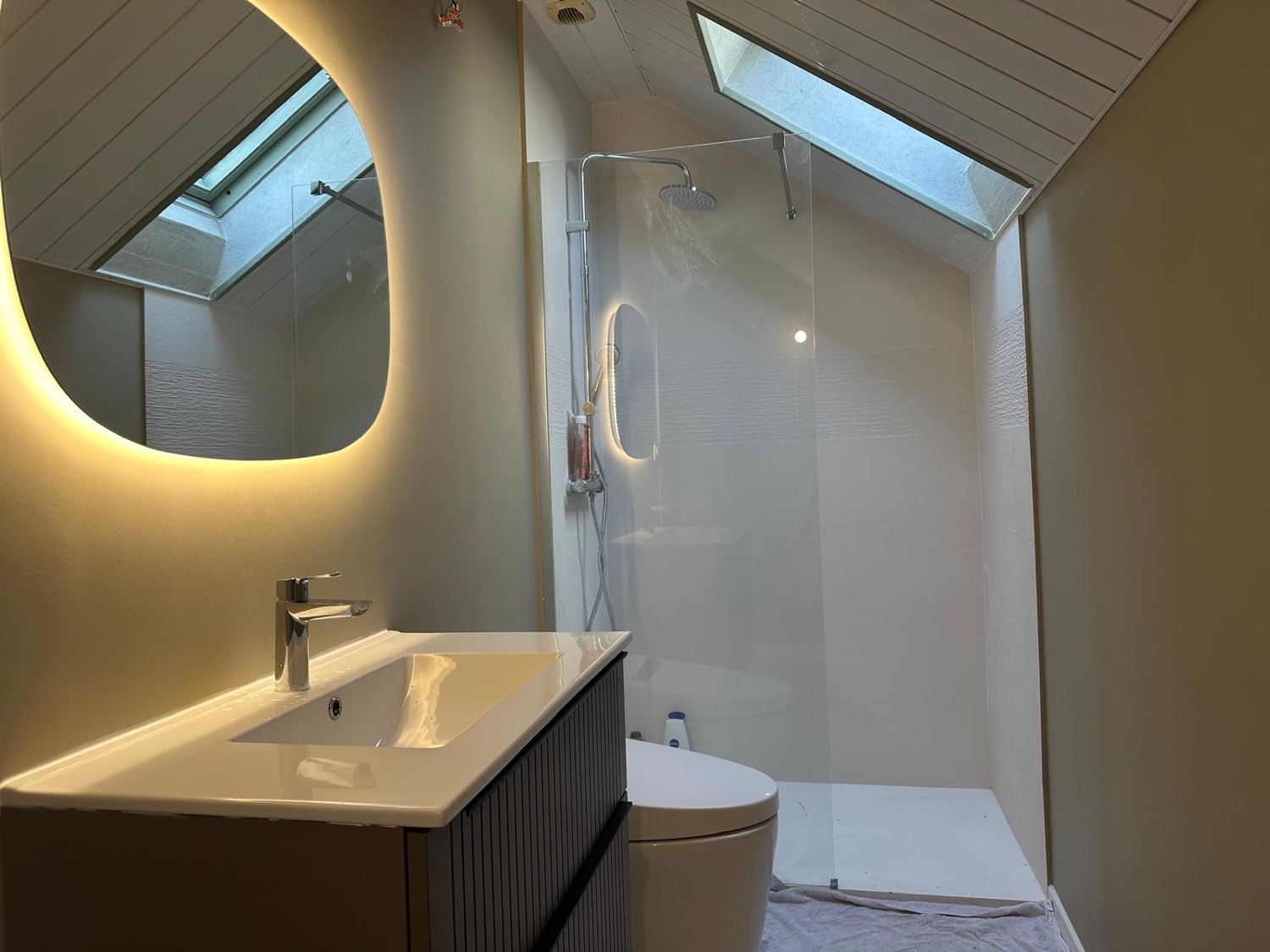 Salle de bain rénovée à Honfleur avec meuble vasque, miroir rétroéclairé et douche à l'italienne