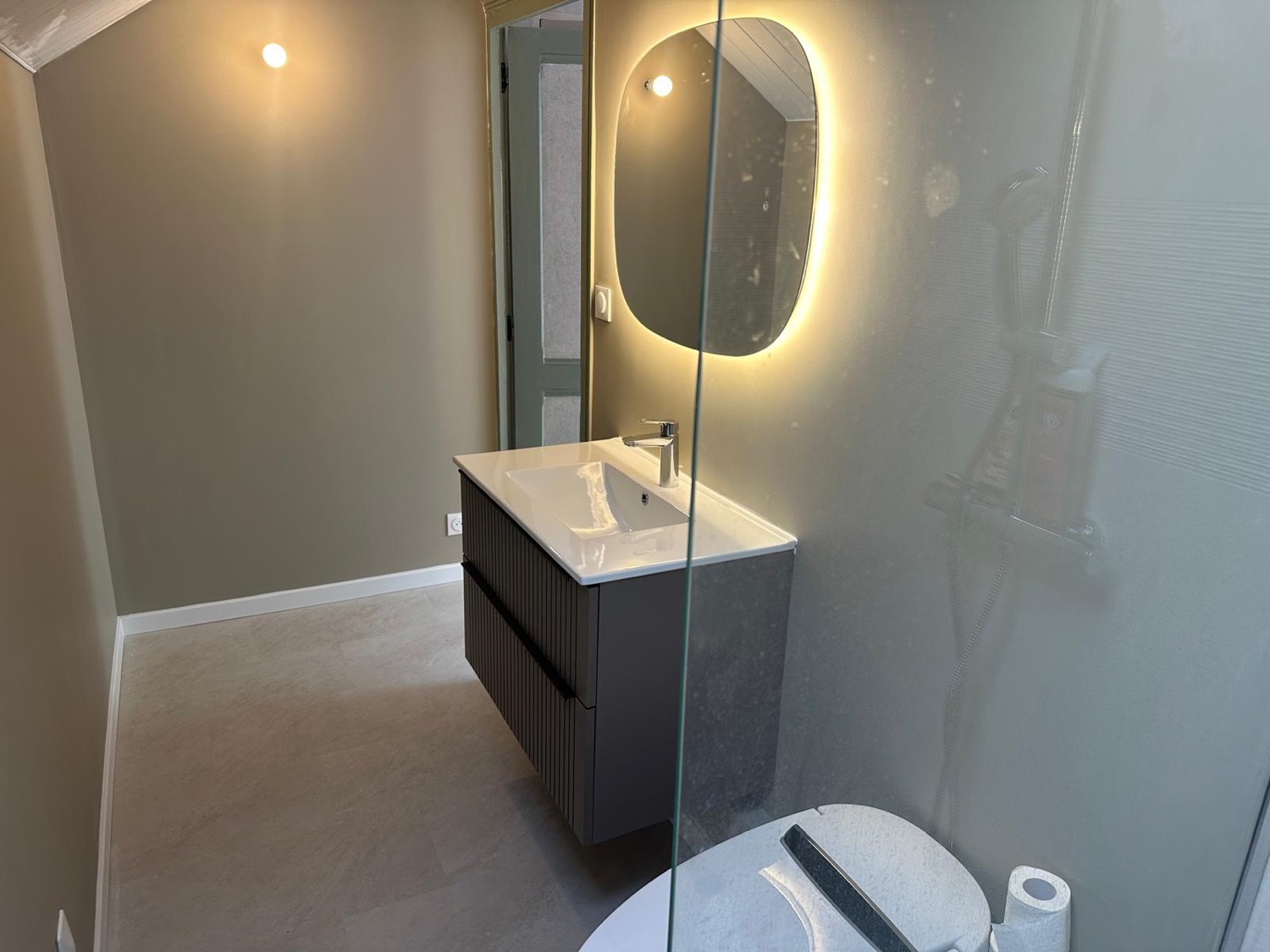 Douche à l'italienne avec paroi vitrée, meuble vasque et miroir rétroéclairé