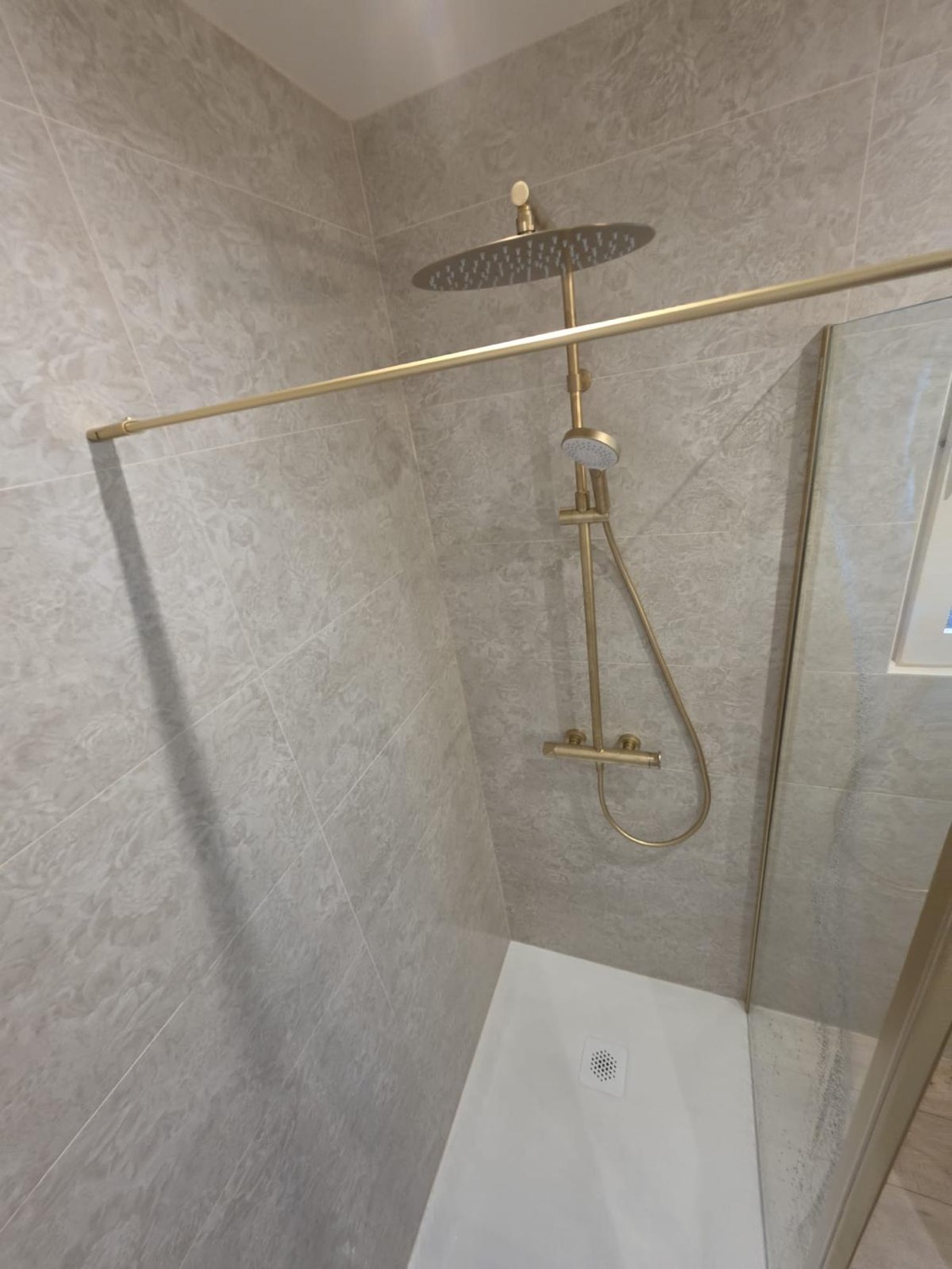 Douche à l'italienne avec colonne de douche en laiton et faïence effet pierre