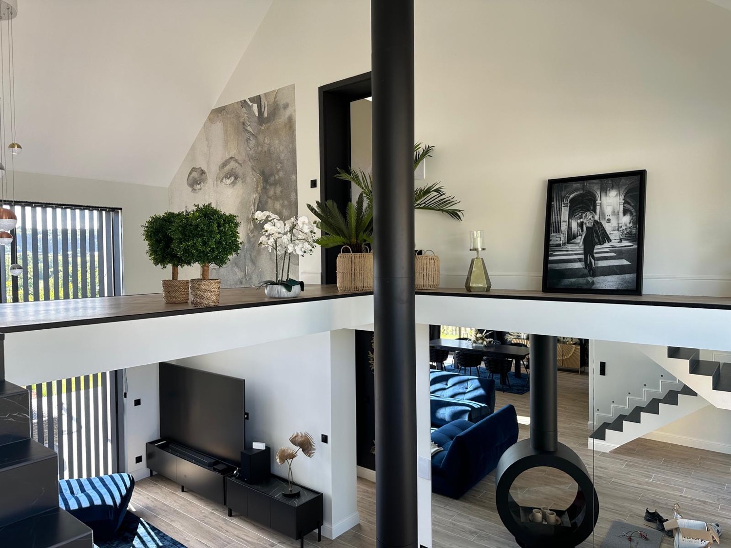 Séjour double hauteur vu depuis la mezzanine, poêle suspendu et plafond cathédrale